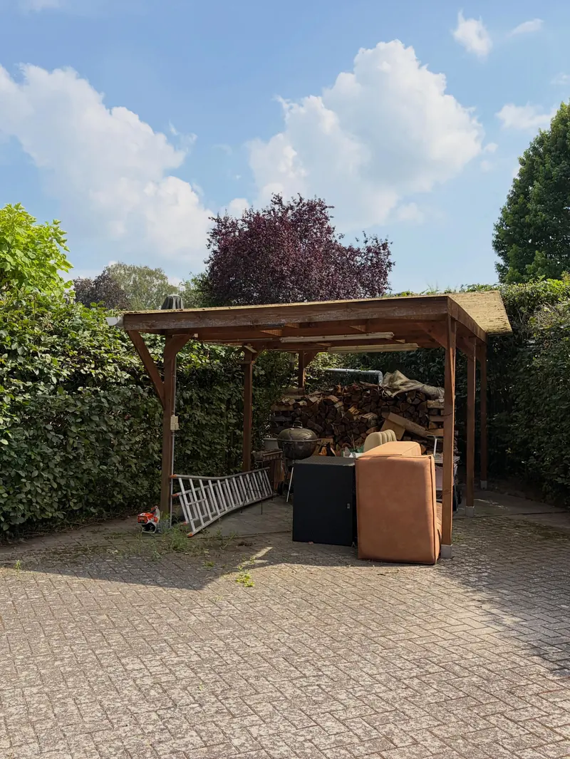 Na: de carport vrij, met strak geschoren hagen errond
